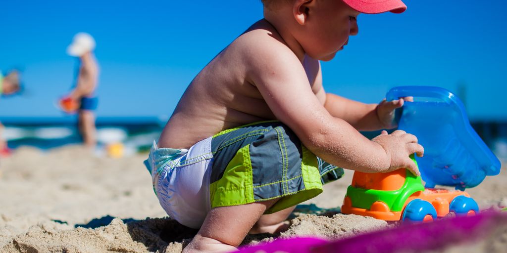 Urlaub mit Kindern am Meer - family beach vacation with children playing and parents relaxing