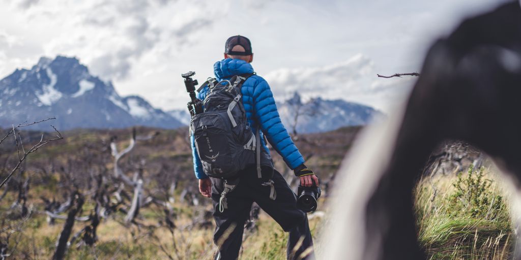 a man with a backpack walking through a field