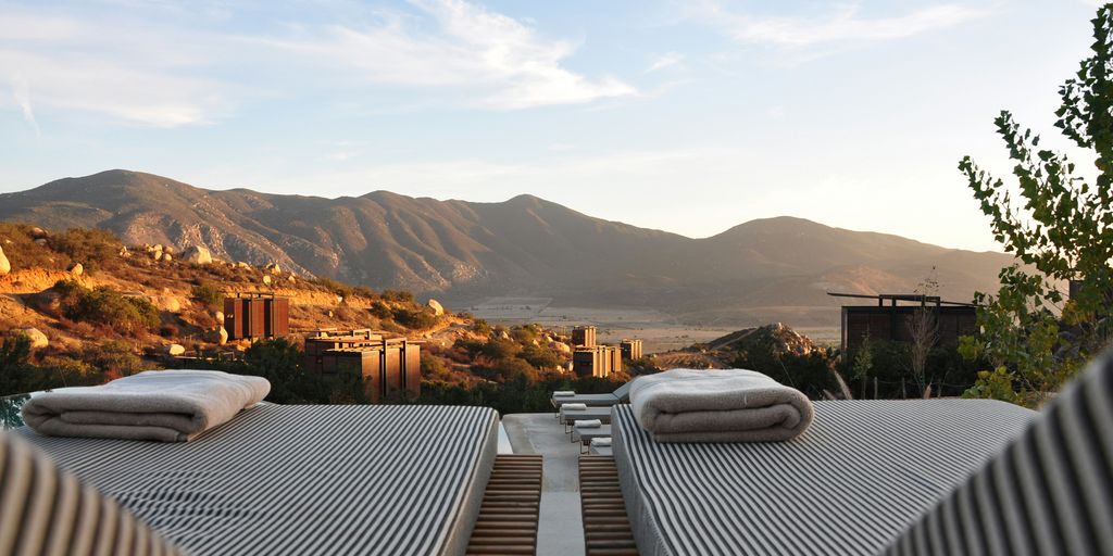 Luxusreisen Angebot - sunloungers fronting buildings near mountain